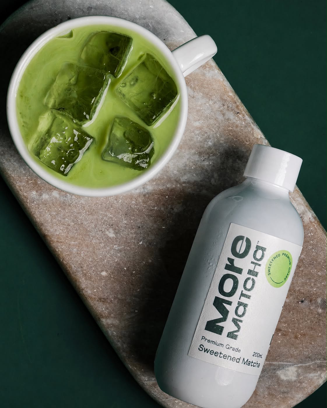 Iced green matcha beside a bottle of More Matcha