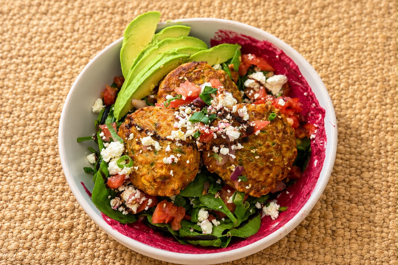 Mediterranean bowl with corn and zucchini fritters, avocado, feta and salad