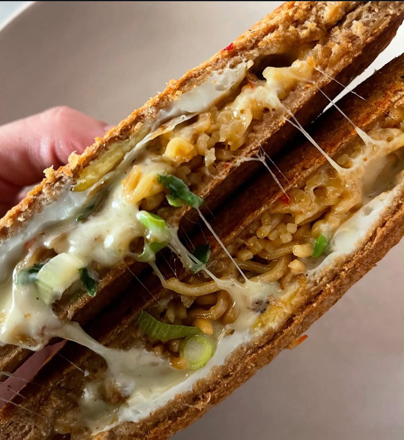 Close-up of the Miss Indo jaffle with noodles, fried egg, shallots and melted cheese