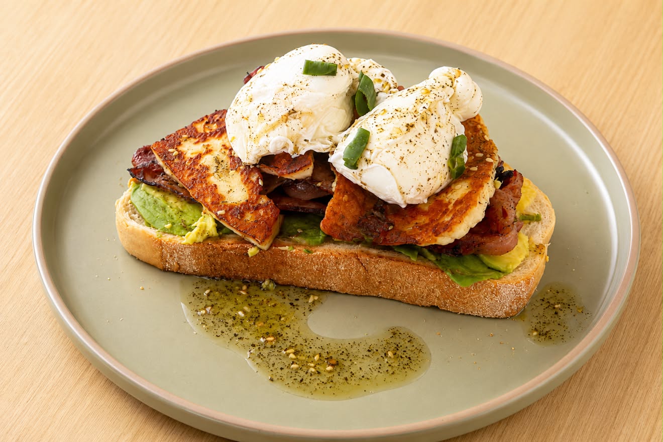 The Cove Stack with poached eggs, avocado, grilled halloumi and bacon on sourdough